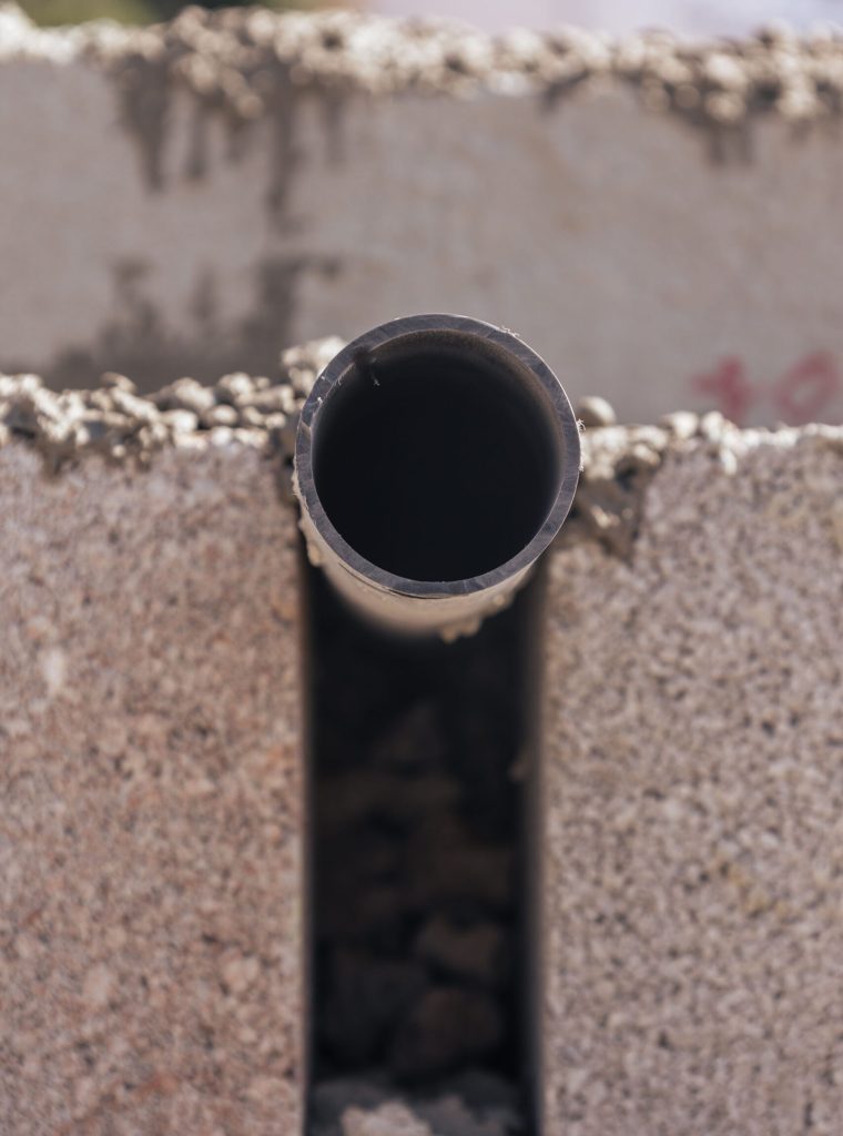 vertical-shot-of-a-sewer-pipe-being-built-under-gr-2023-09-18-15-49-13-utc-min-scaled.jpg